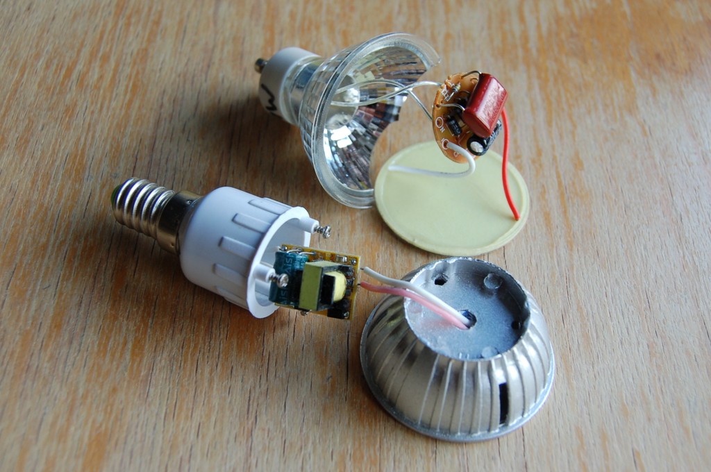 Front: EMI dirty LED bulb with unfiltered buck converter, recognisable by its yellow transoformer; Back: EMI clean LED bulb with a big, red‑coloured series high‑voltage capacitor.